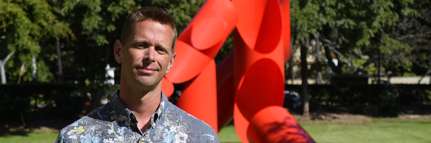 Prof. Brown Standing In Front Of The Gate Of Hope Sculpture.