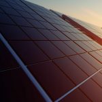 Photo of sun setting over some solar panels