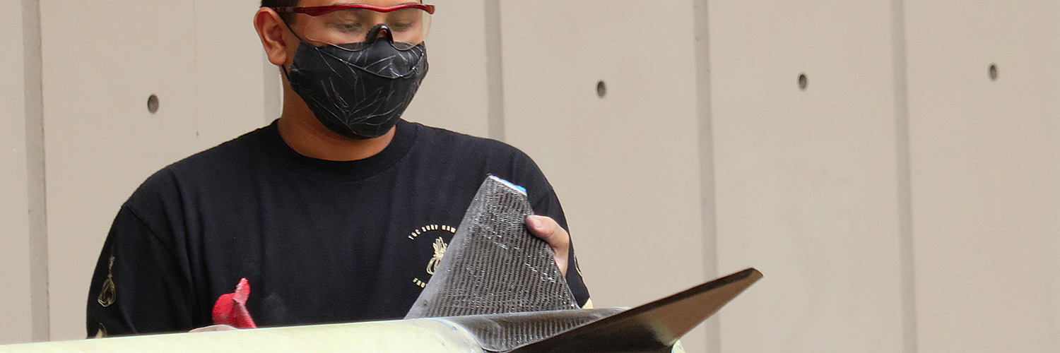 Student Sanding The Fins Of A Rocket