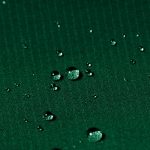 Water beads on a green fabric