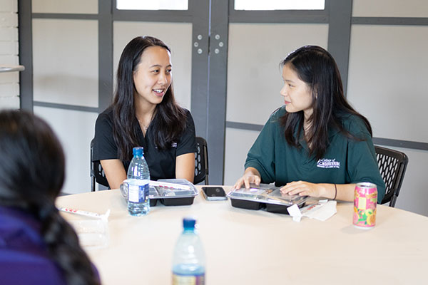Two Wāhine Connect Students Conversing