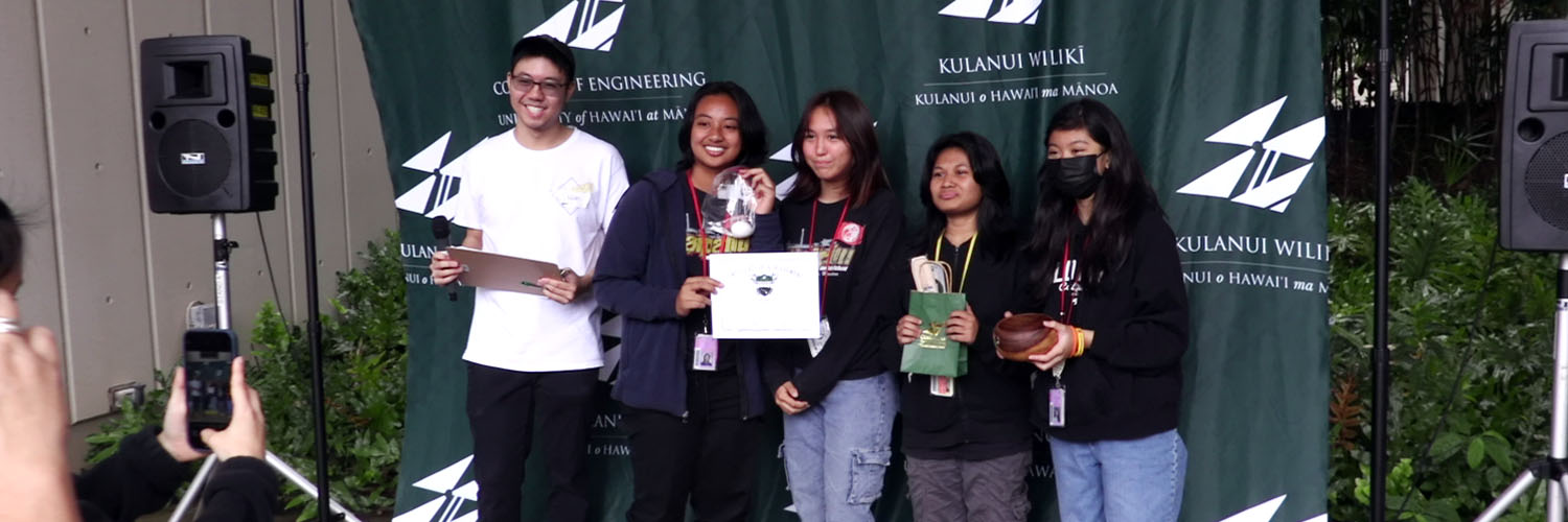 A Team Of Students Posing With Their Award